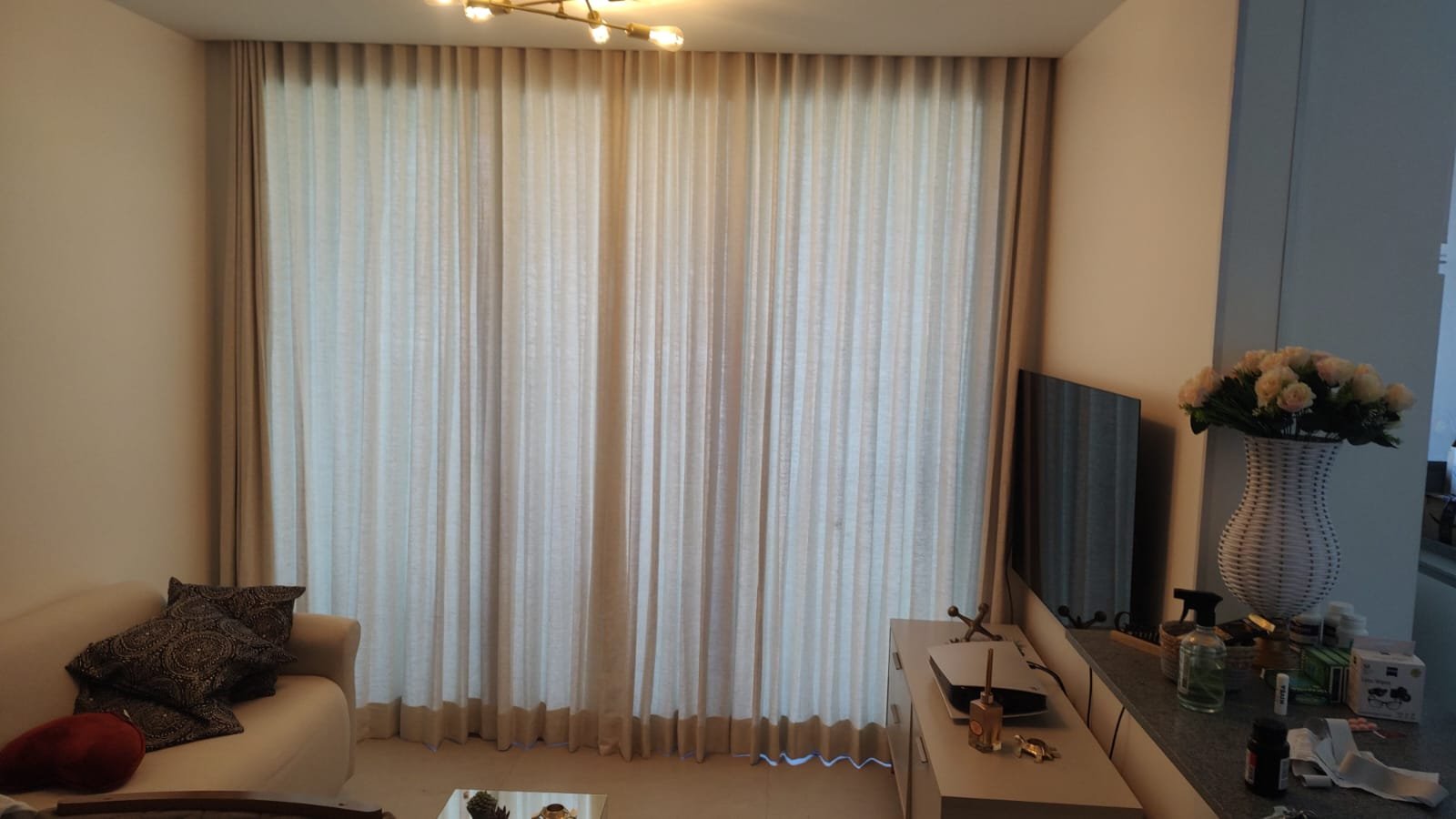Sala com cortina bege do teto ao piso