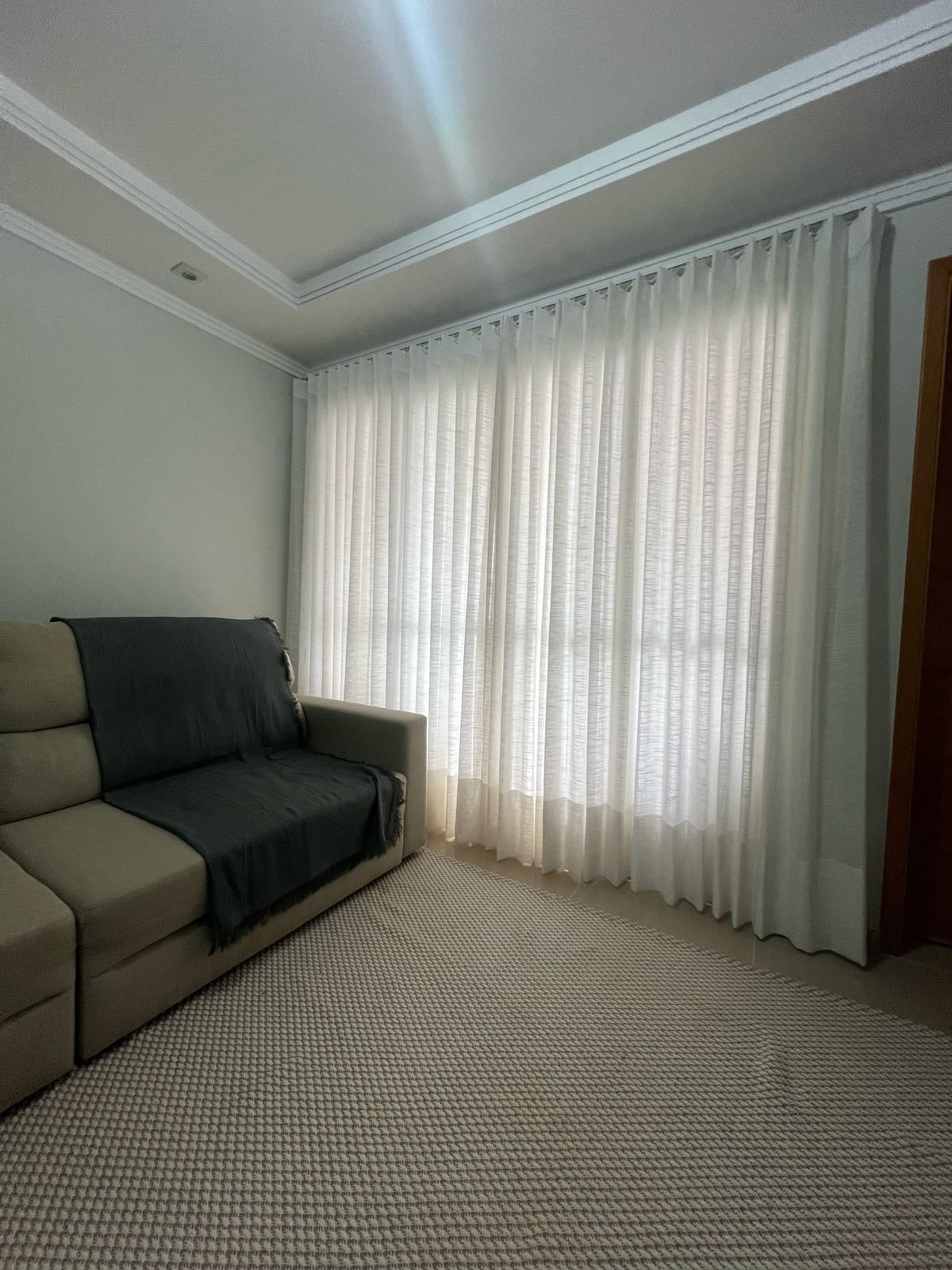Sala clara com cortina translúcida