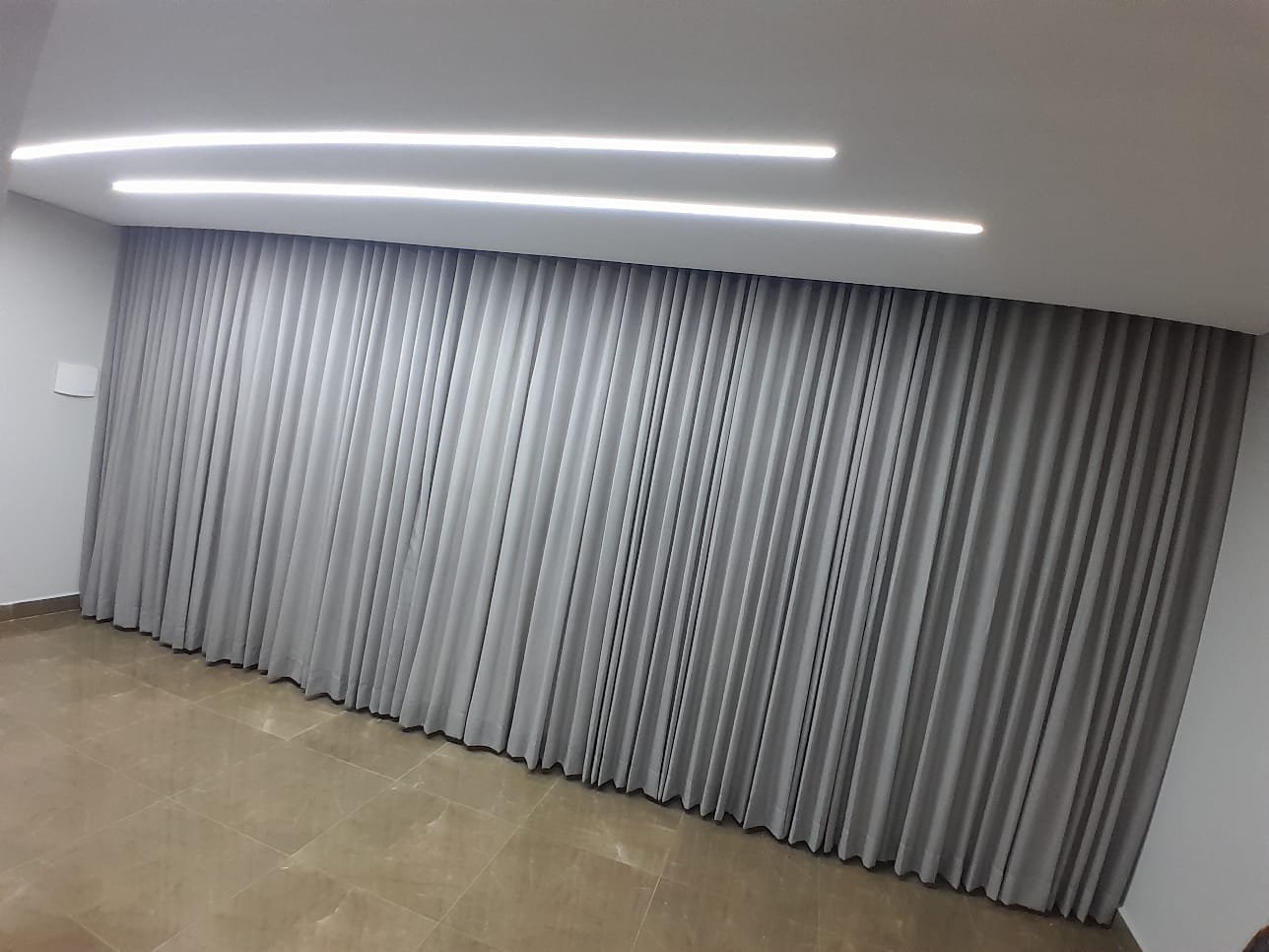Cortina cinza em ambiente amplo